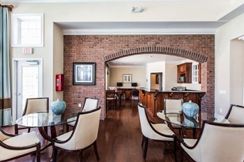 A dining room with a table and chairs and a brick wall